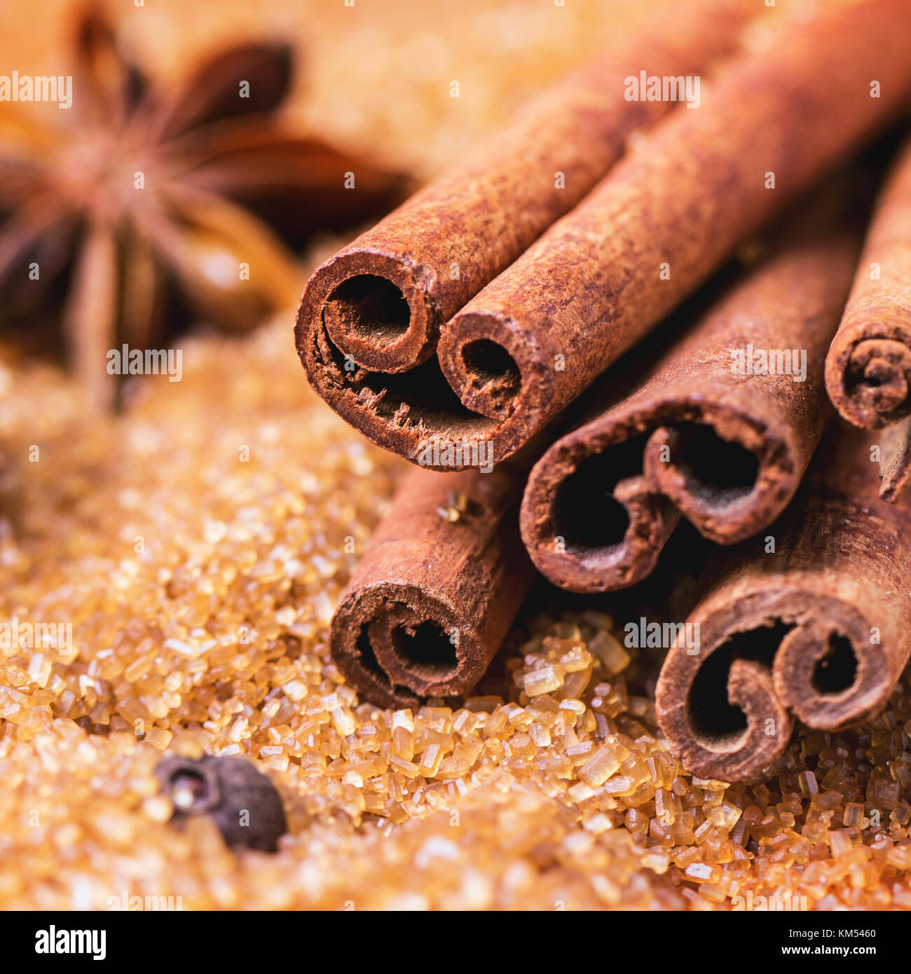 Spices allspice, cinnamon and anise over heap of brown sugar. Square image with selective focus Stock Photo