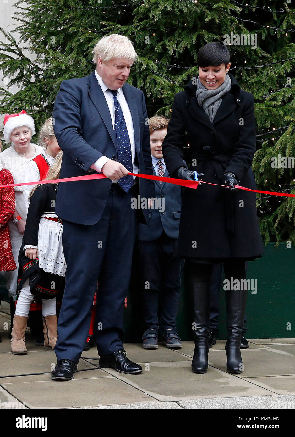Foreign Secretary Boris Johnson with Norway's Foreign Secretary Ine Eriksen Soreide as she cuts a ribbon during the unveiling of a Christmas tree, gifted by Norway, outside The Foreign and Commonwealth Office (FCO) in London, after their bilateral talks. Stock Photo