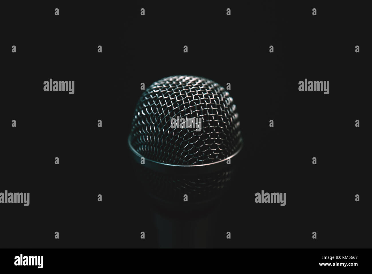 Audio microphone isolated on dark background. Music concert or talent show concept with copy space. Stock Photo
