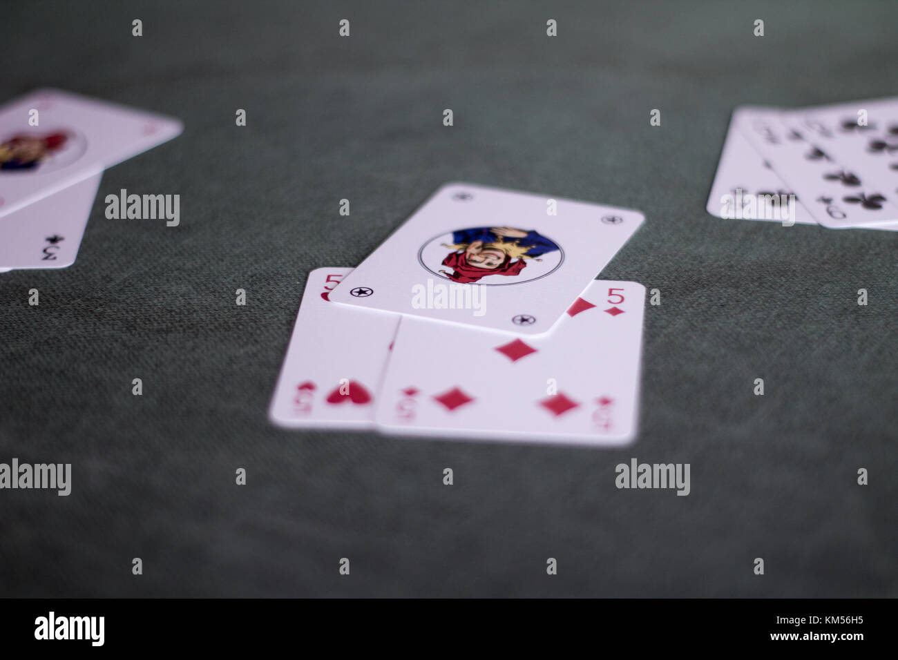 https://c8.alamy.com/comp/KM56H5/12-4-2017-greece-joker-card-on-a-green-mat-and-other-cards-from-the-KM56H5.jpg