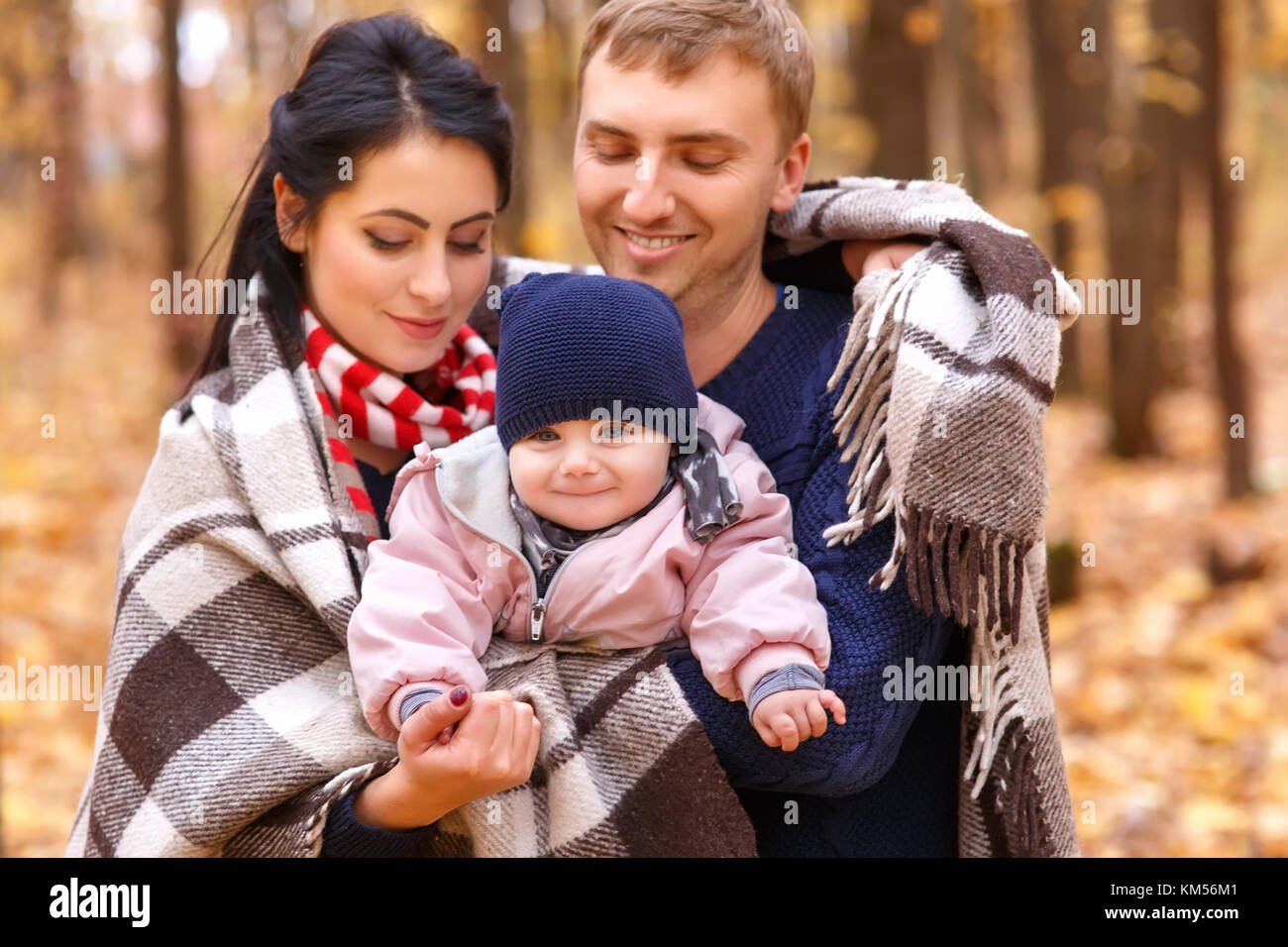 mom and dad holding baby girl in hands Stock Photo