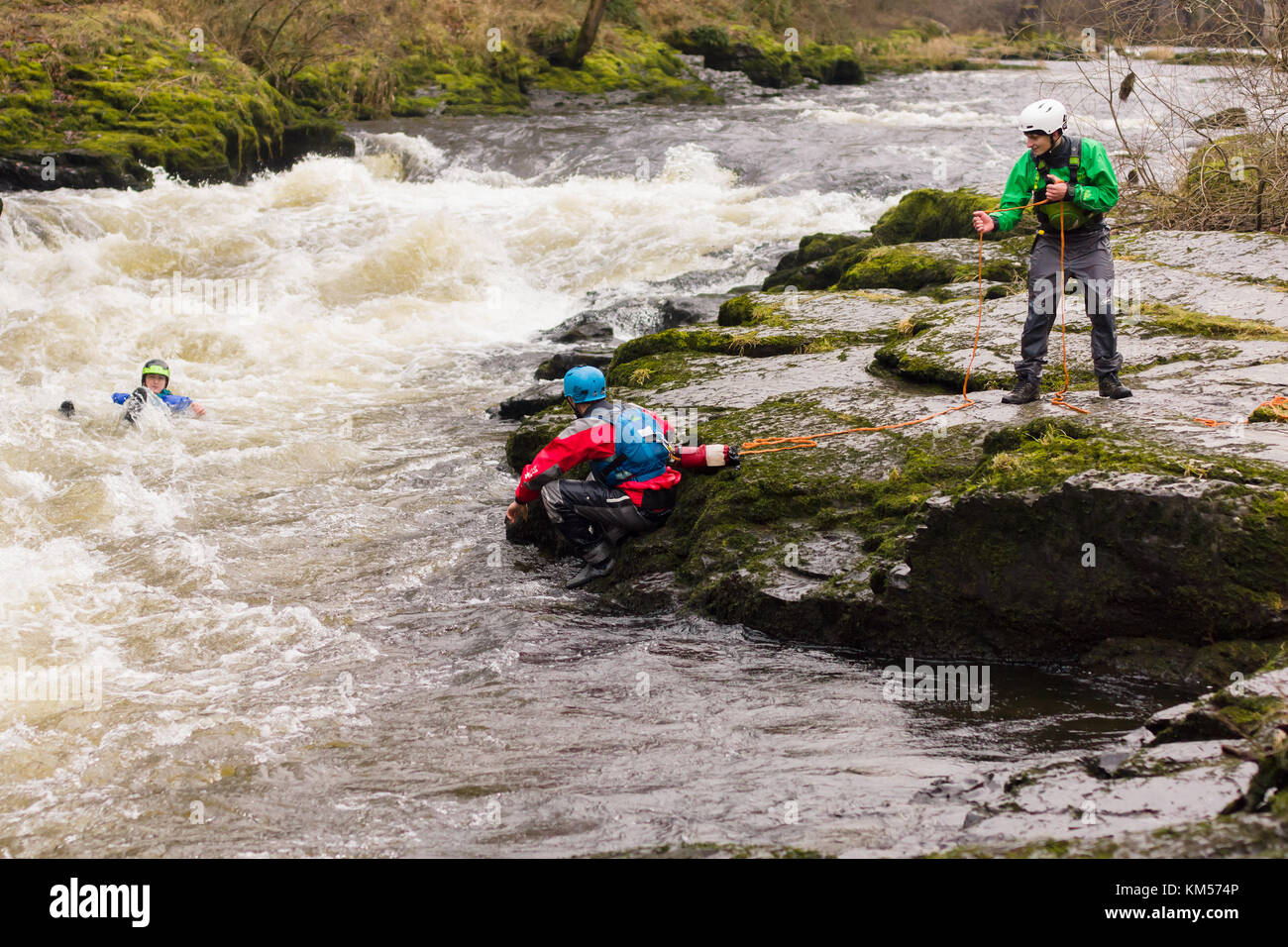 White water kayakers practicing rescue techniques with a throw line at the Serpents Tail on the River Dee in North Wales Stock Photo
