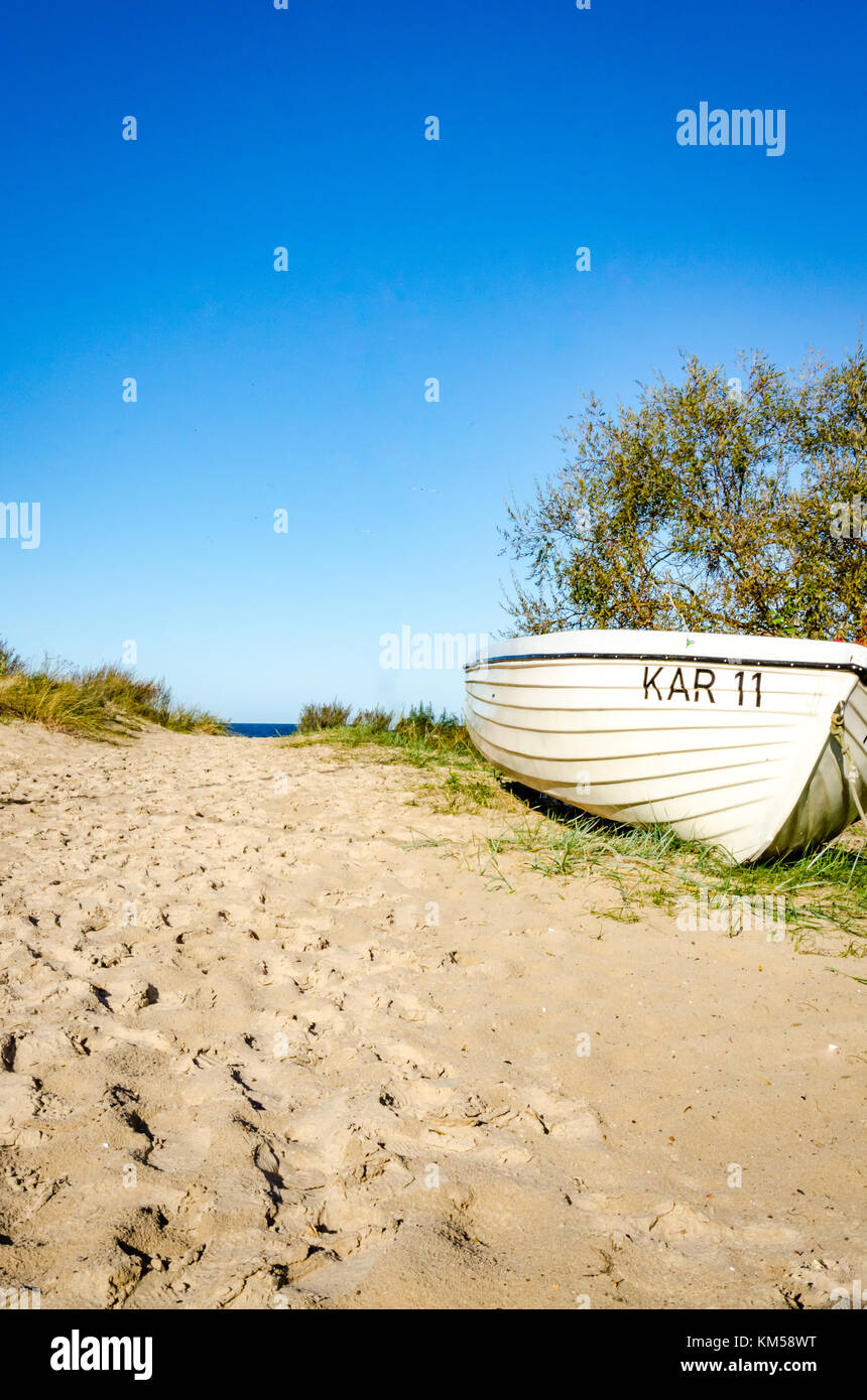 Beach with sand dunes and boat. High portrait format with empty space for headline and copy. Stock Photo