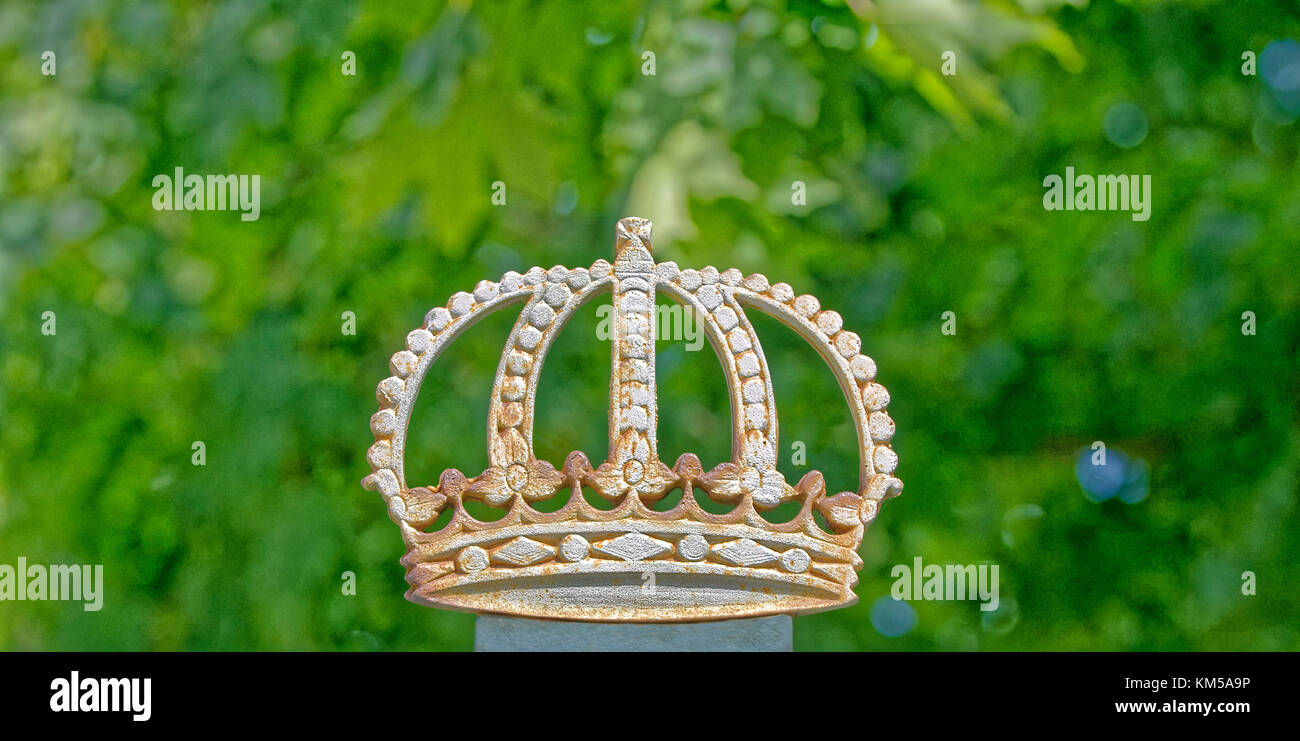 The Royal Crown on a fence at Drottningholms Castle with a green background Stock Photo