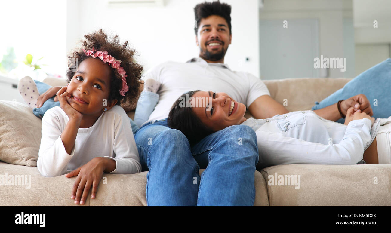 Young girl watching tv with her parents Stock Photo