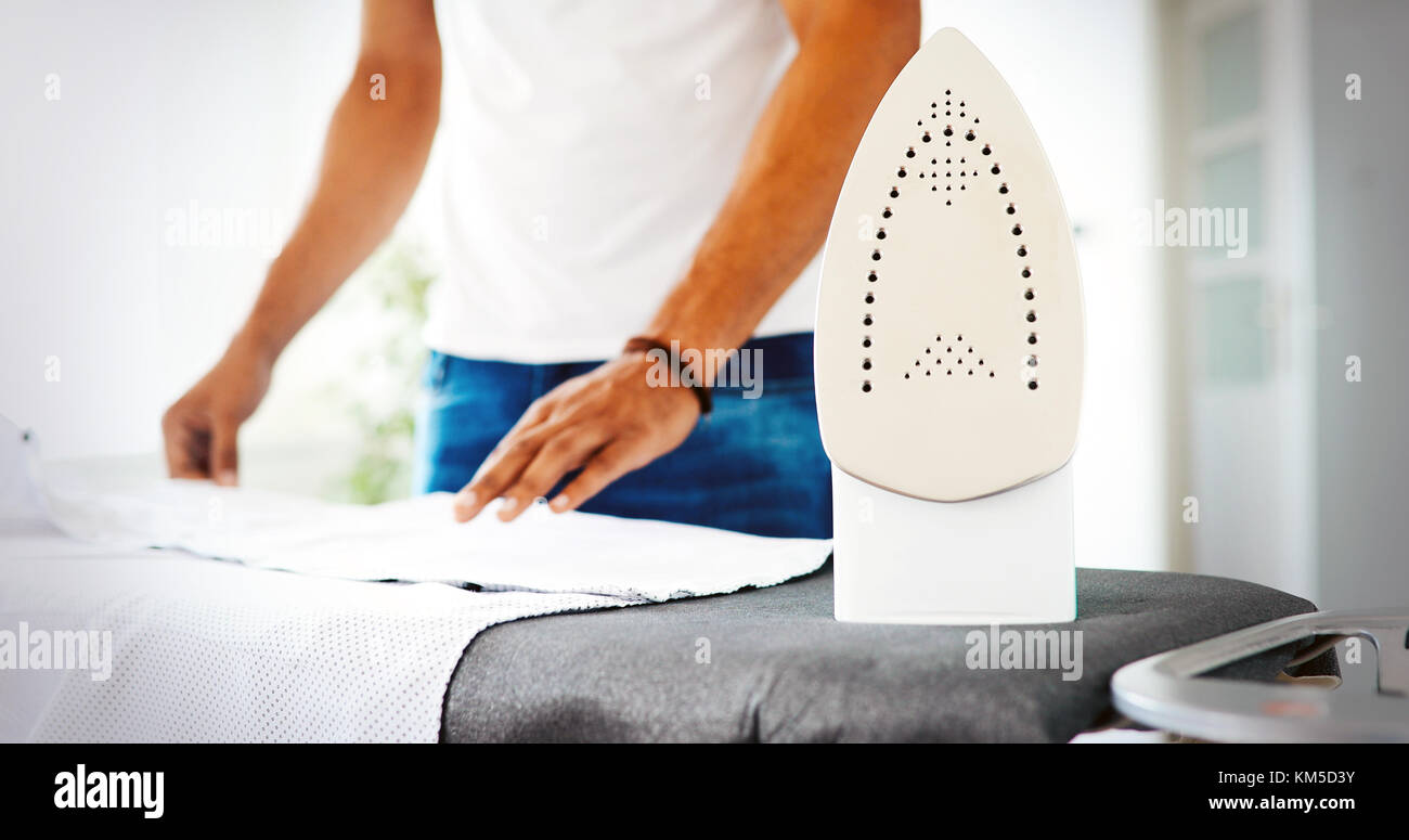 Man ironing shirt on ironing board Stock Photo