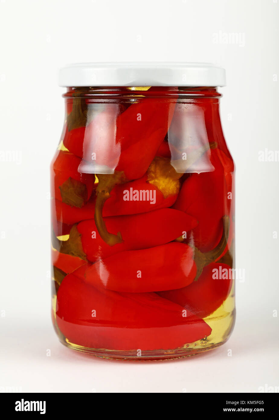 Close up of one glass jar of pickled red hot cherry chili pepperoncini