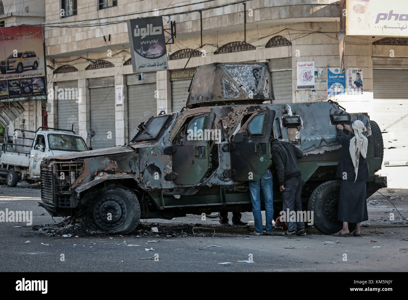 Sanaa, Yemen. 05th Dec, 2017. Yemeni men inspect a military vehicle destroyed in clashes between Houthi fighters and forces loyal to Yemen's former President Ali Abdullah Saleh in Sanaa, Yemen, 05 December 2017. Saleh was killed by Houthi rebels on Monday. Credit: Hani Al-Ansi/dpa/Alamy Live News Stock Photo