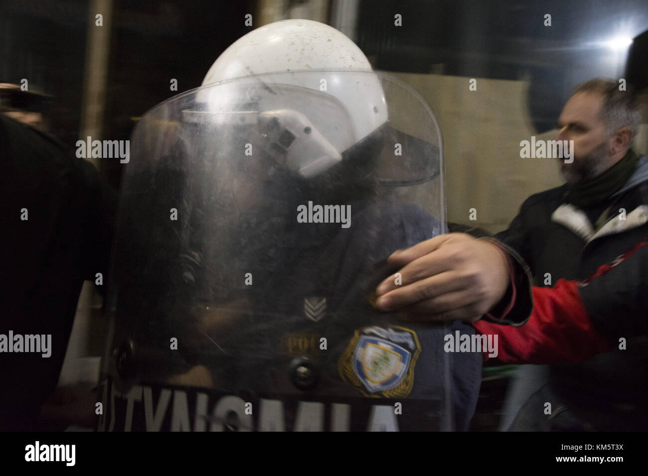 Athens, Greece. 5th Dec, 2017. Protesters escort a riot policeman to his unit after they broke the shutters of the Ministry of Labor and stormed it's entrance. Thousands, mostly members of PAME, the workers' union affiliated to the communist party, took to the streets to protest against a law, the government attempted to introduce, that would make it harder for unions to go on strike. Credit: Nikolas Georgiou/ZUMA Wire/Alamy Live News Stock Photo