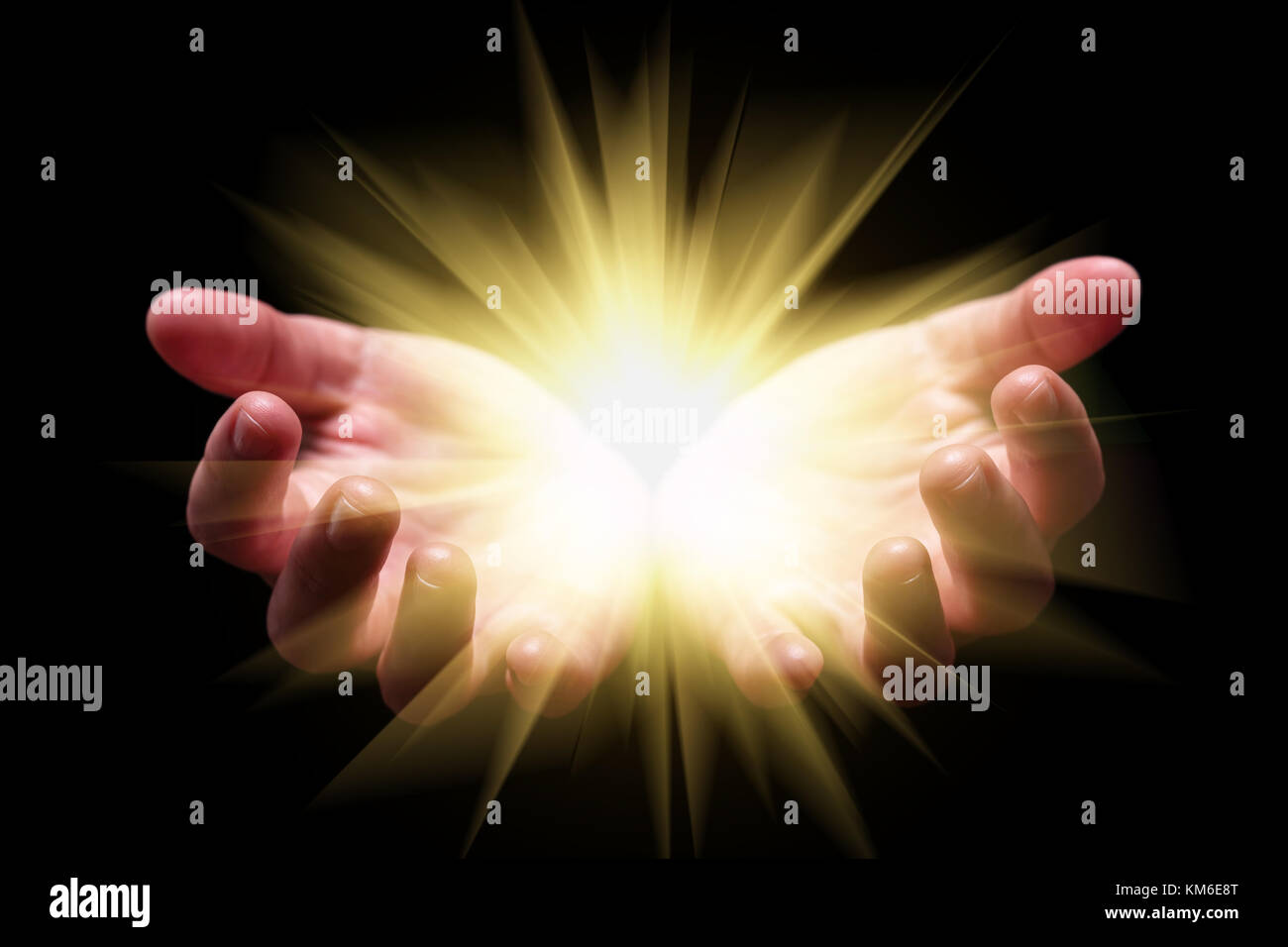 Woman hands cupped holding showing emanating bright glowing radiant shining light emitting rays beams religion divine celestial heavenly big bang Stock Photo