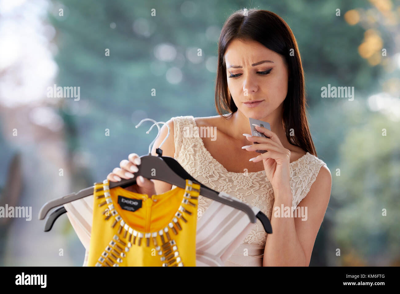 Girl looking doubtful purchasing clothes Stock Photo