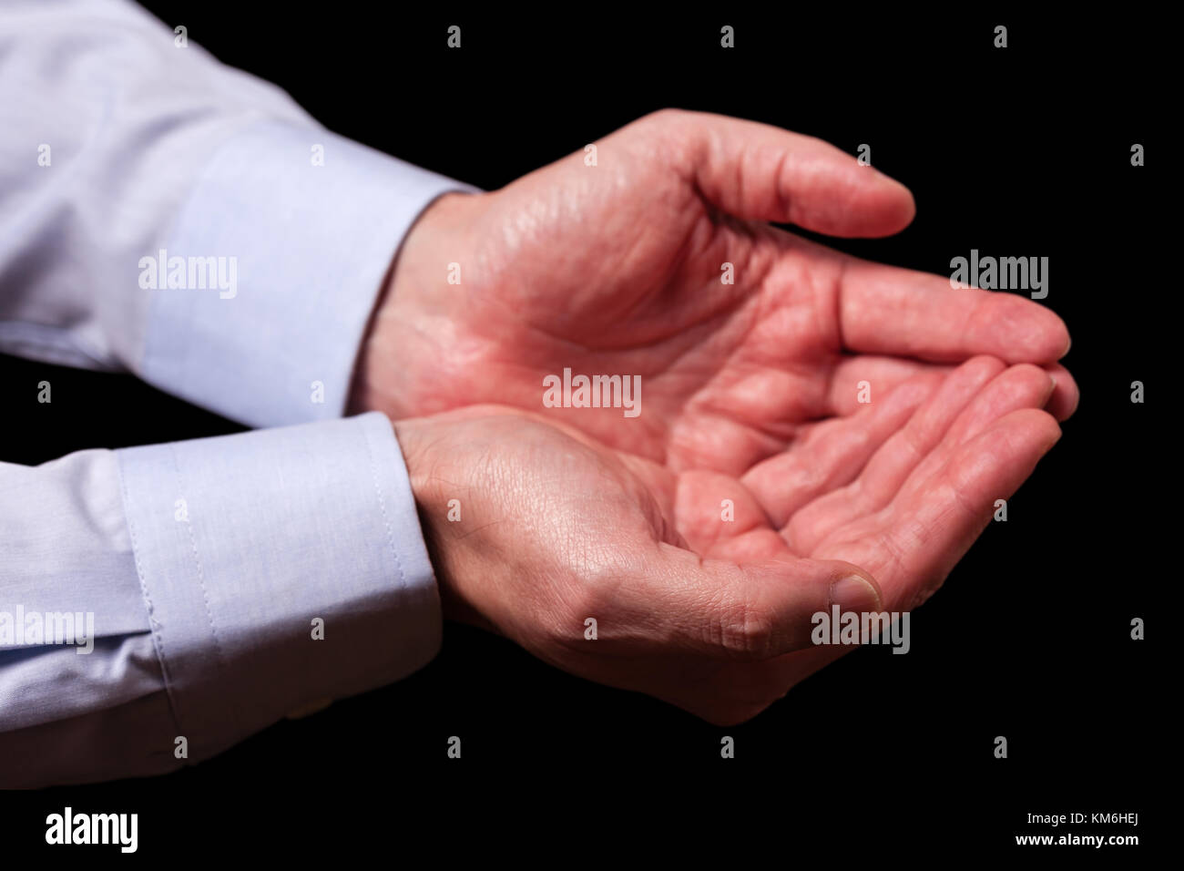 Mature male businessman hands together with empty palms up. Concept for man praying prayer faith religion religious worship or giving offering begging Stock Photo
