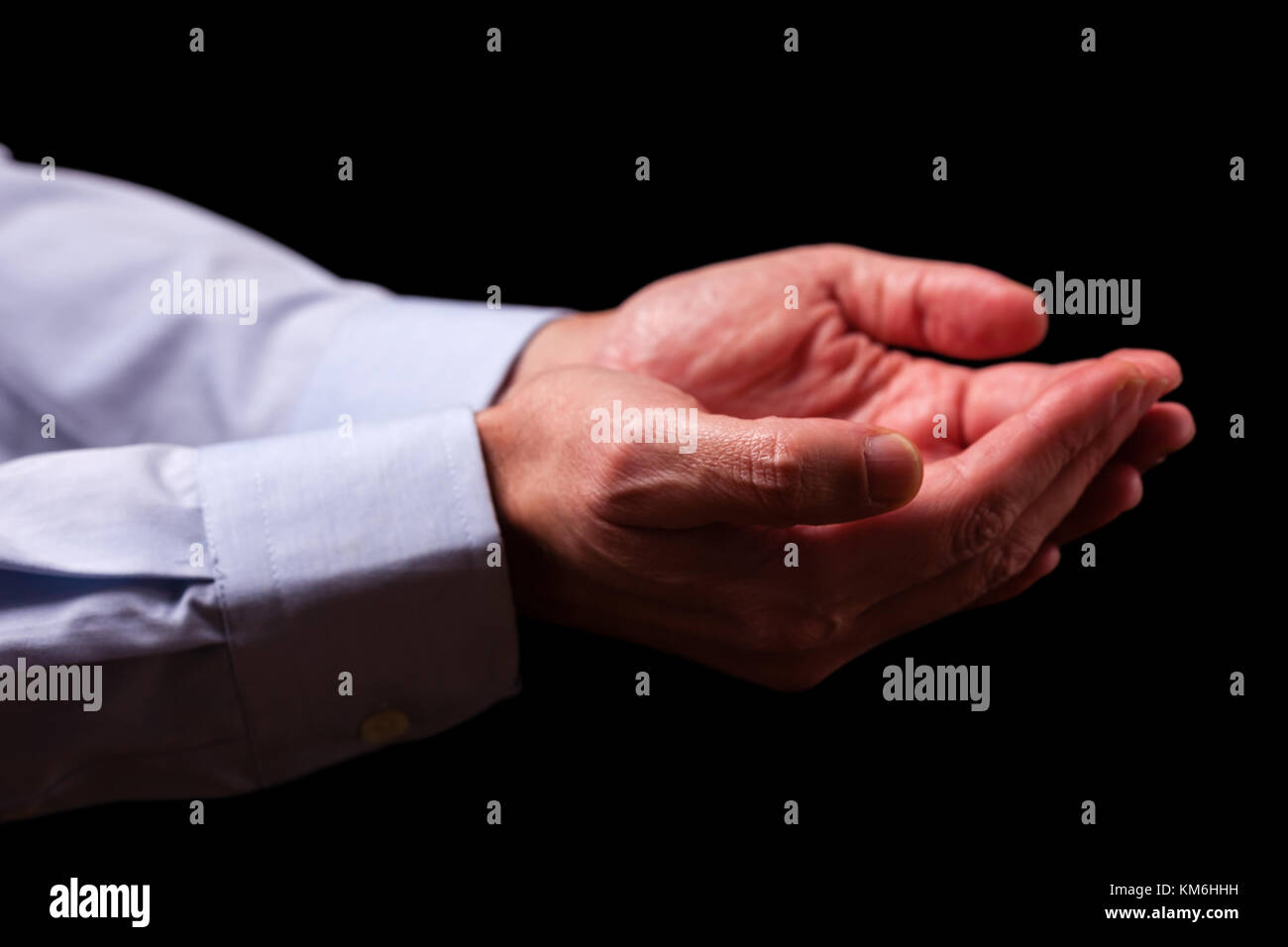 Mature male businessman hands together with empty palms up. Concept for man praying prayer faith religion religious worship or giving offering begging Stock Photo