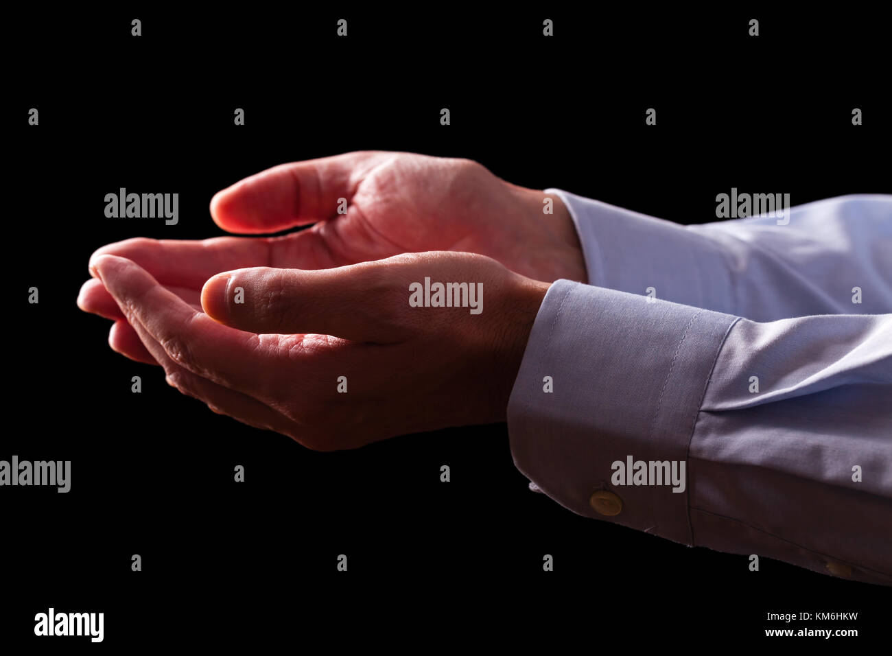 Mature male businessman hands together with empty palms up. Concept for man praying prayer faith religion religious worship or giving offering begging Stock Photo