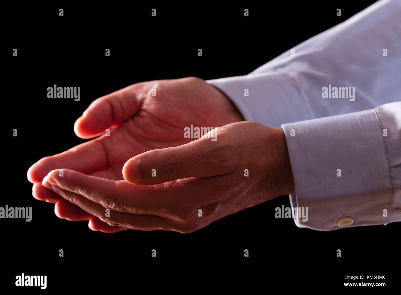 Mature male businessman hands together with empty palms up. Concept for man praying prayer faith religion religious worship or giving offering begging Stock Photo