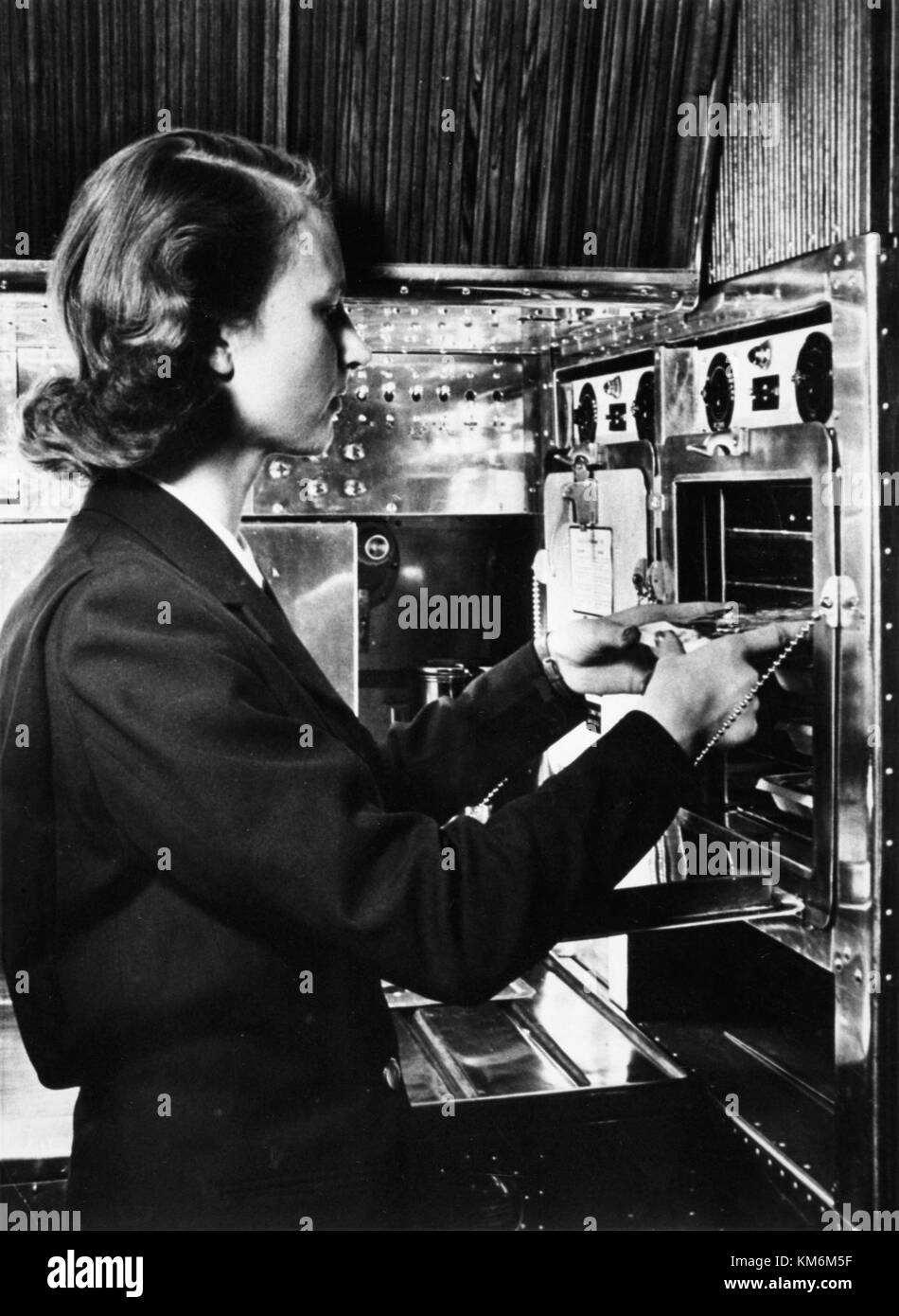 A 1950s interior of a Scandinavian Airlines System (SAS) DC 4 aircraft, showing the onboard service area with a flight attendant. This image captures the early days of air travel. Stock Photo