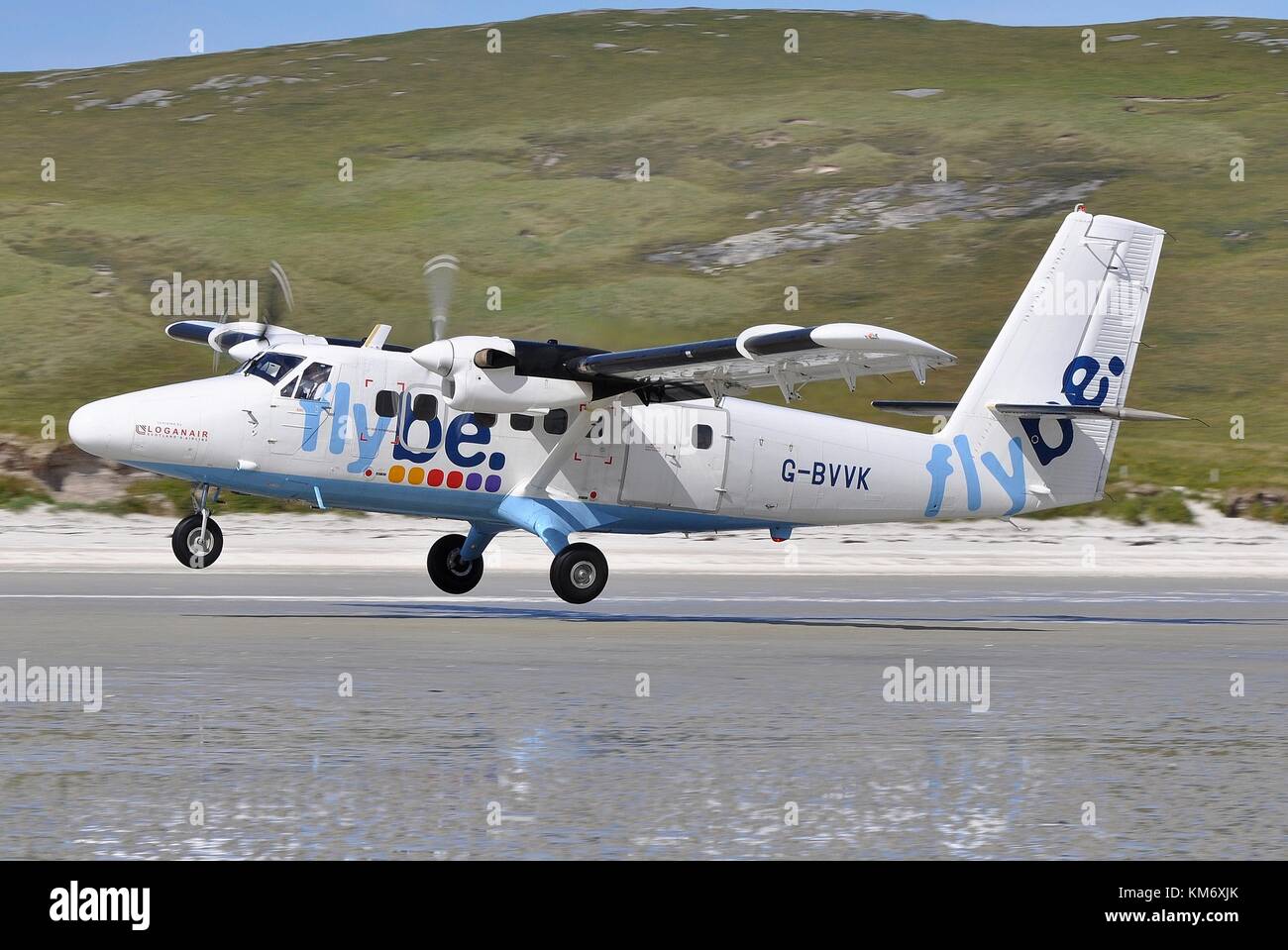 BEACH RUNWAY ON THE ISLAND OF BARRA, OUTER HEBRIDES. G-BVVK DHC-6-300 TWIN OTTER OF LOGANAIR OPERATED ON BEHALF OF FLYBE. SCHED SERVICE FROM GLASGOW. Stock Photo