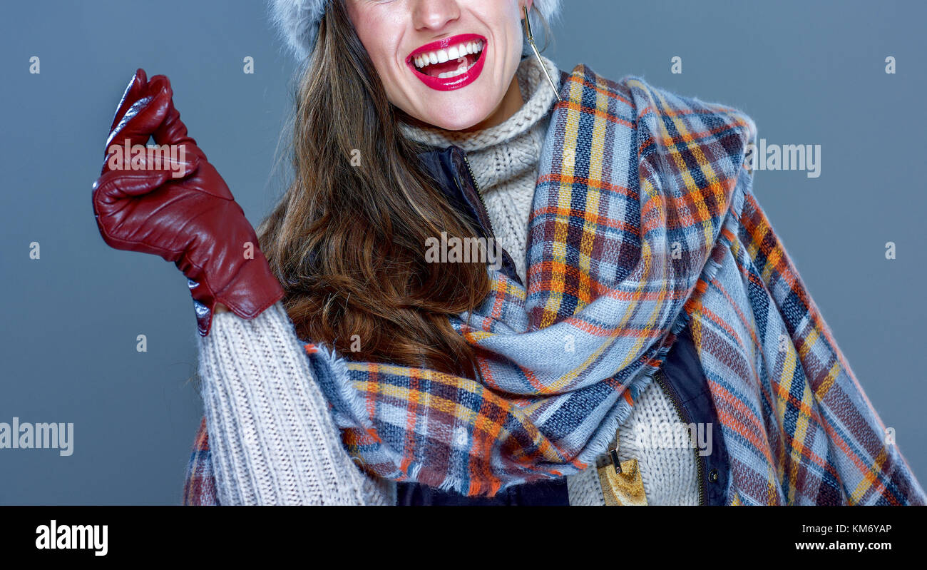 Winter things. Closeup on smiling trendy woman in fur hat isolated on cold blue snapping fingers Stock Photo