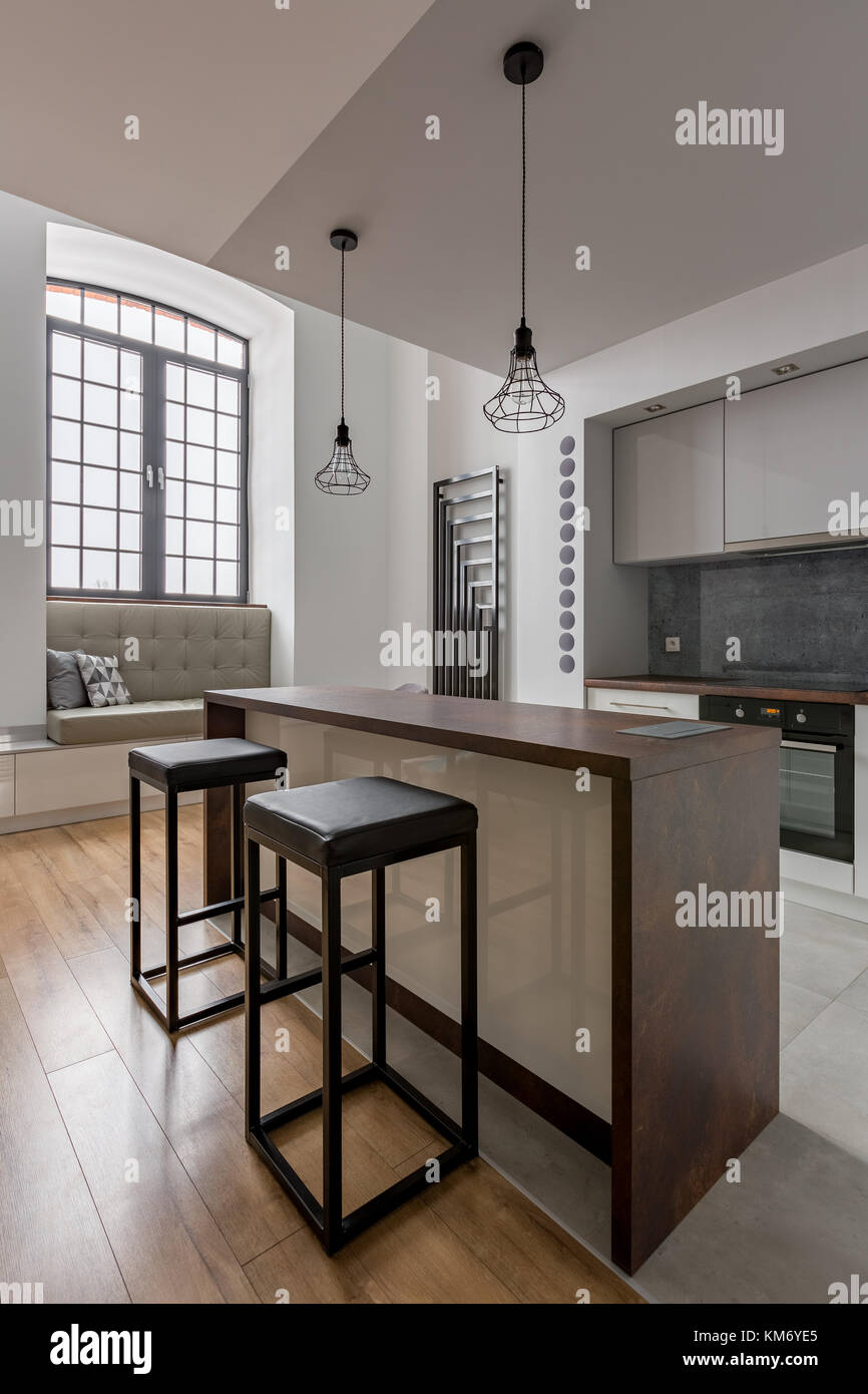 Modern kitchen with big window, island and simple stools Stock Photo ...
