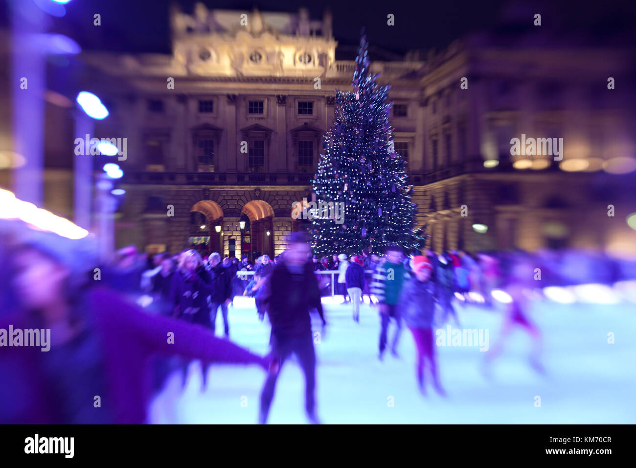Ice skaters glide at night on the temporary ice rink at Somerset House ...