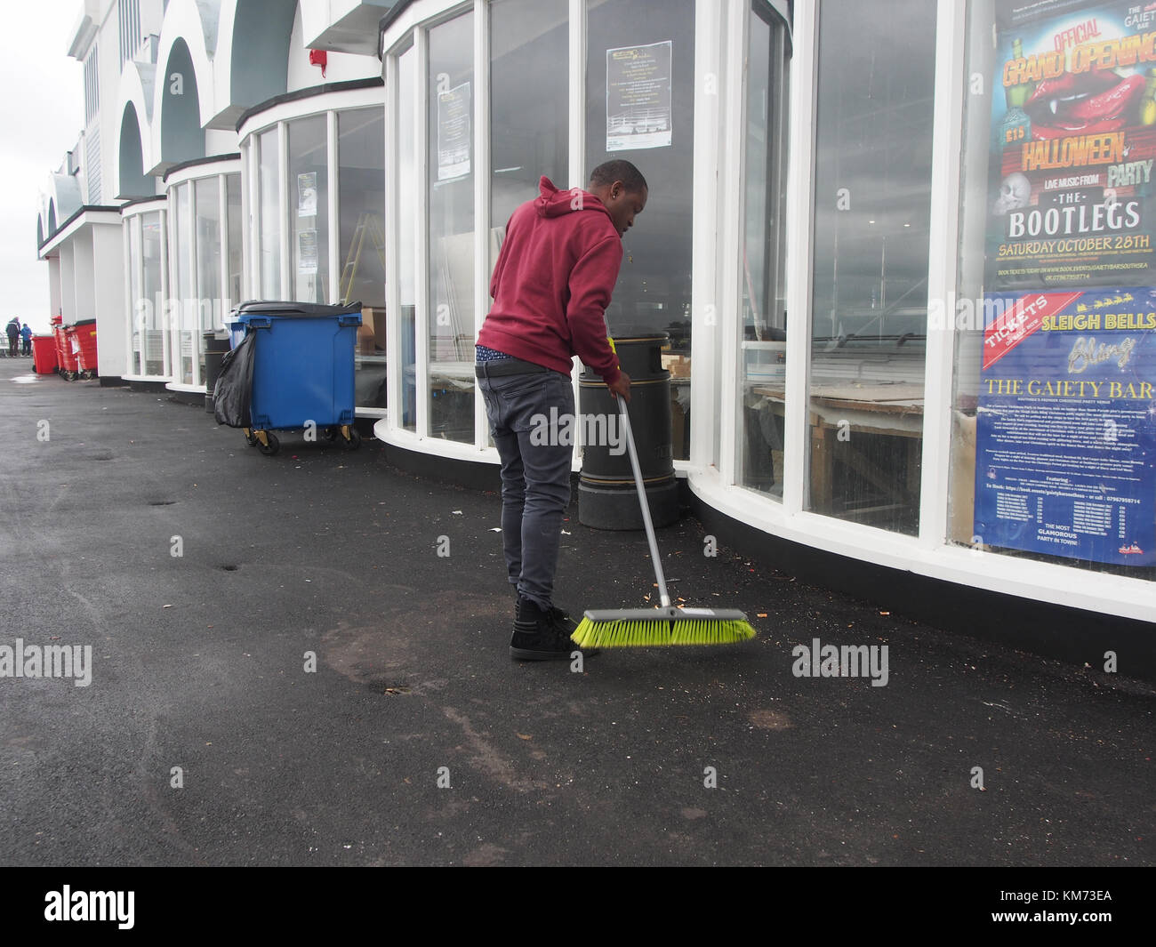 A man sweeps the walkways on South Parade Pier, Southsea, Portsmouth, England Stock Photo