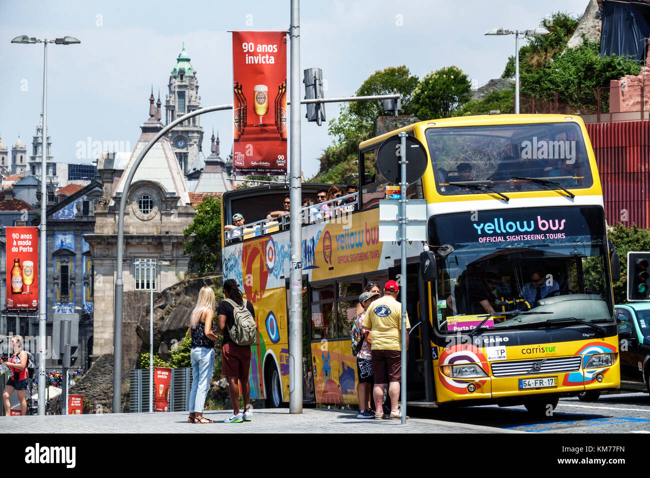 Porto Portugal,Santo Bento,yellow bus,stop,double-decker,skyline,light pole banner,ad advertising advertisement,Super Bock beer,marketing,street,Hispa Stock Photo
