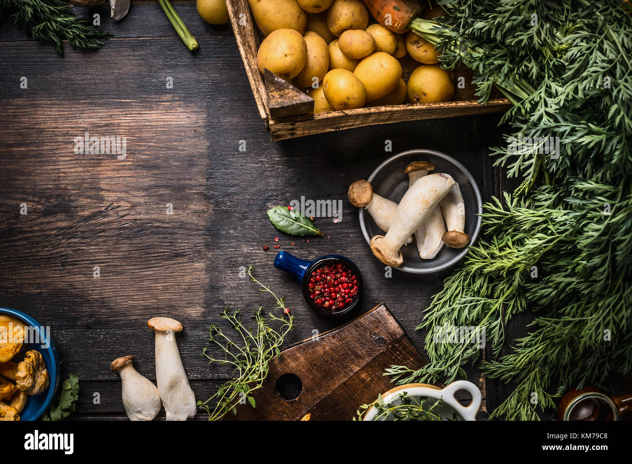 Autumn seasonal cooking ingredients with harvest vegetables, greens , Potatoes and mushrooms on dark rustic kitchen table background, top view, place  Stock Photo