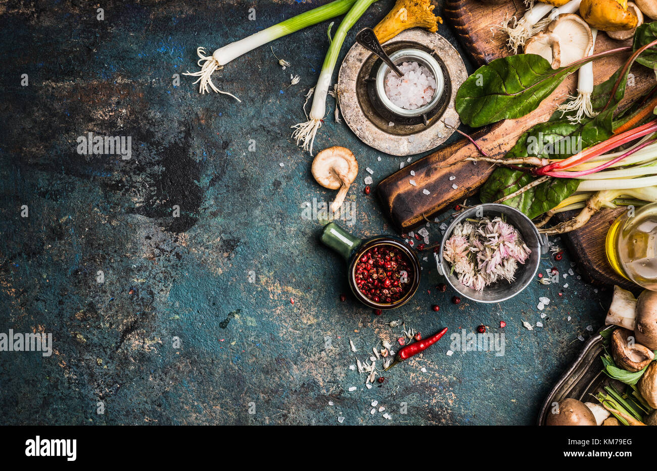Fresh seasoning and vegetarian organic cooking ingredients for tasty cooking on dark rustic background, top view, place for text. Clean healthy organi Stock Photo