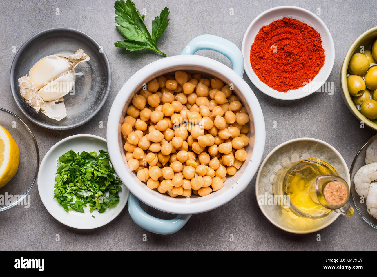 Cooking ingredients in bowls for Chickpea salad on gray concrete background, top view, close up. Healthy , clean food or vegetarian cooking and eating Stock Photo