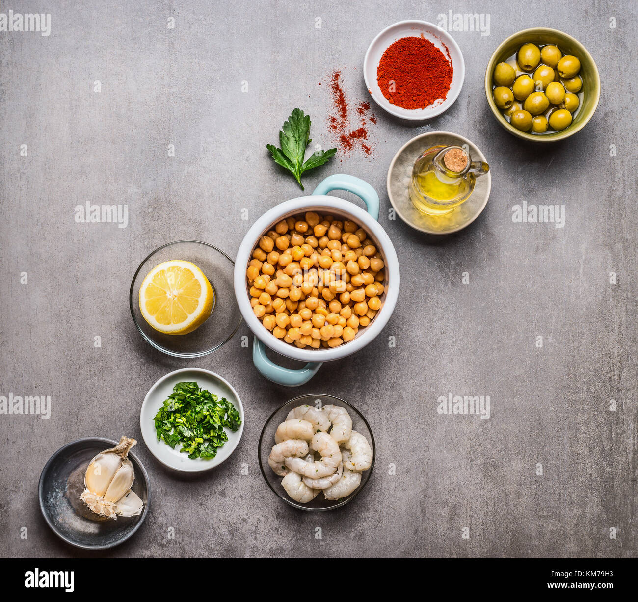 Various cooking ingredients in bowls for Chickpea salad on gray concrete background, top view, copy space. Healthy , clean food or vegetarian cooking  Stock Photo
