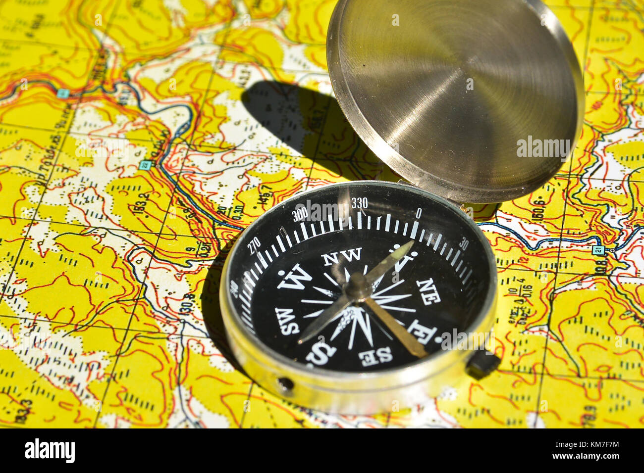 Map and compass - the tools for navigation. The magnetic compass lies on a topographic map Stock 