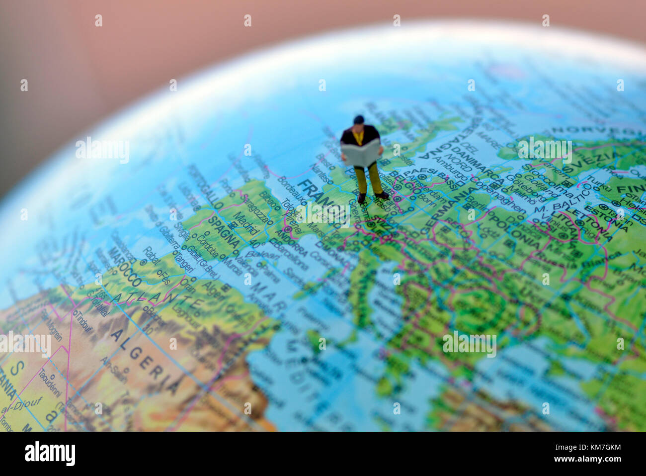 Traveller tourist globetrotter with bags standing on a map of the world globe Stock Photo