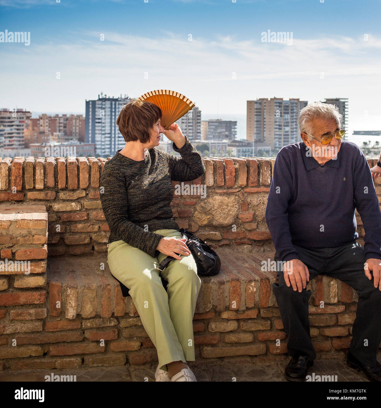 Older Spanish couple, woman using fan for sunshade Stock Photo
