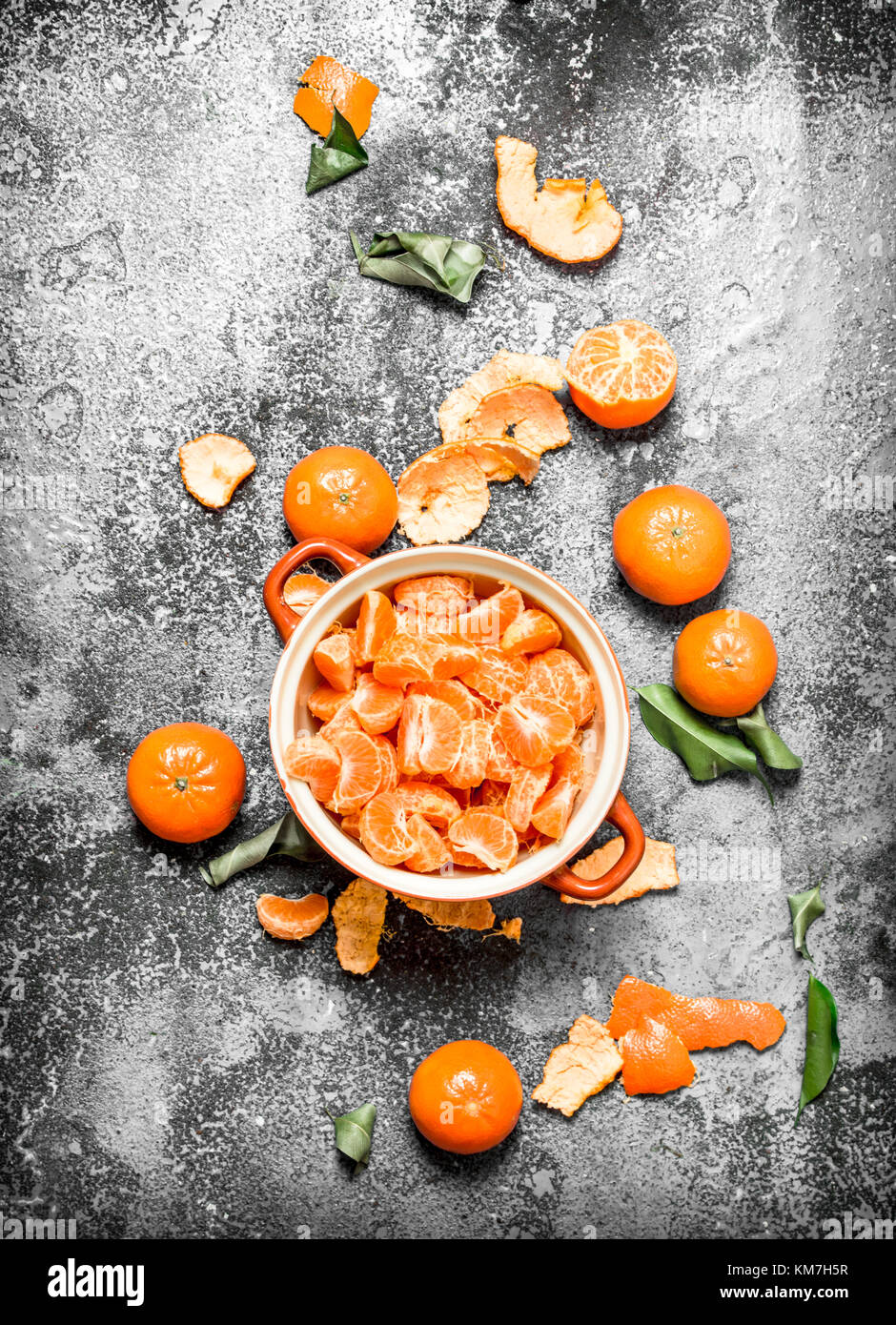 Peeled tangerines in a bowl. On rustic background. Stock Photo