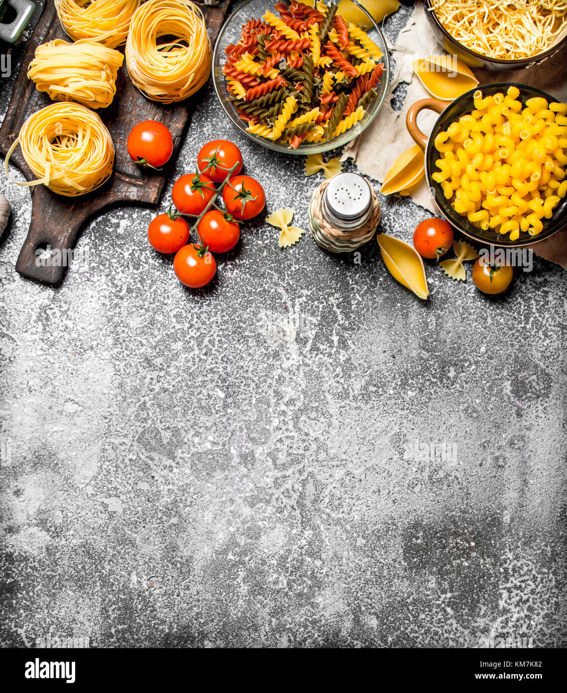 Pasta background. Pasta with sauces, vegetables and olive oil.On rustic ...