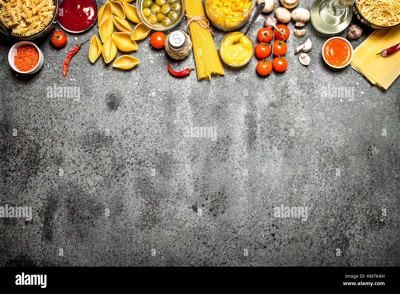 Pasta background. Various pasta with spices and vegetables. On rustic ...