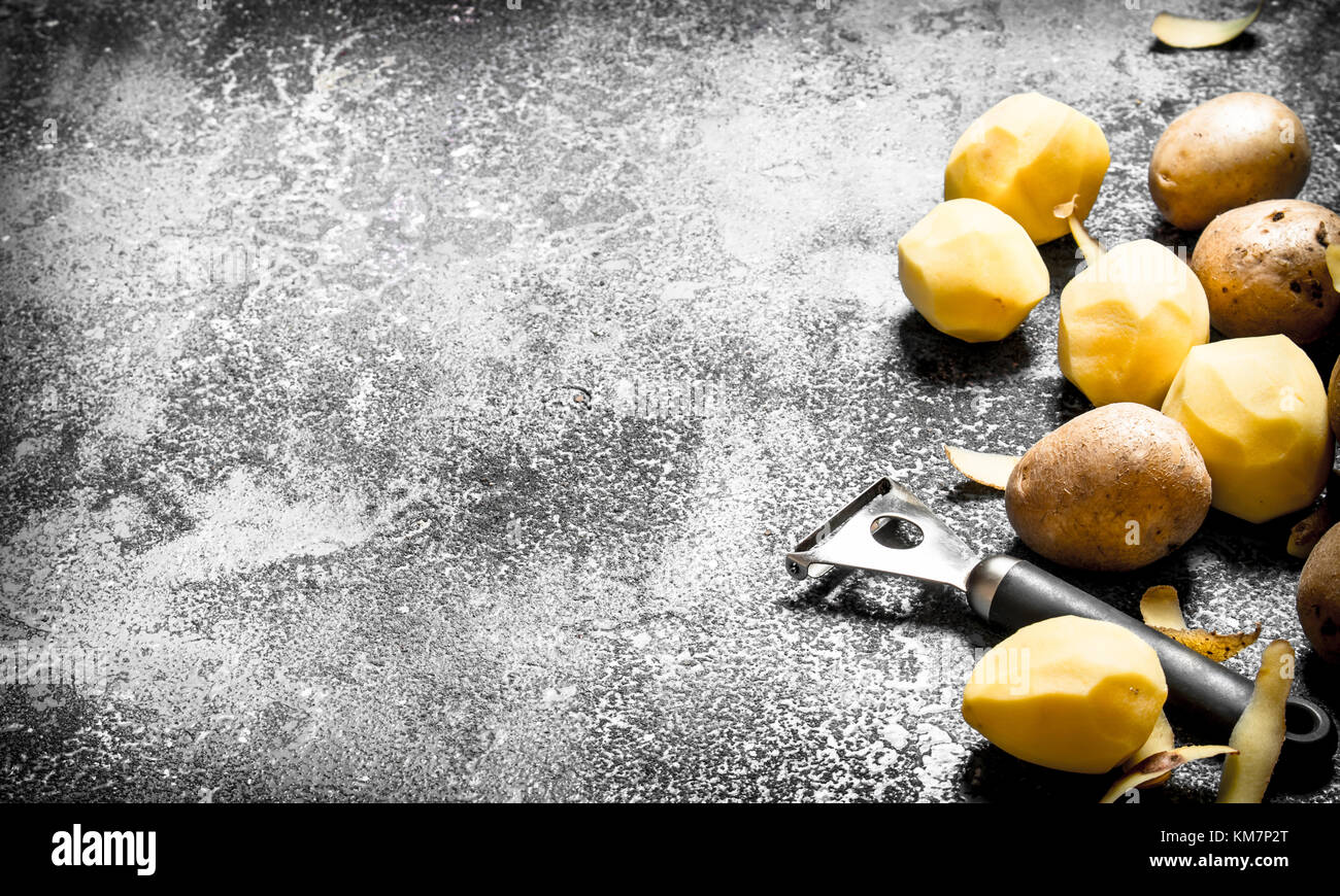Peeled organic potatoes. On the rustic background Stock Photo - Alamy