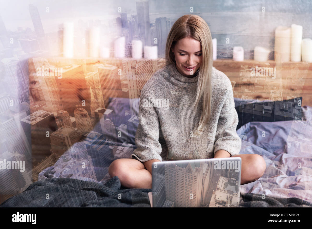 Nice cheerful woman sitting on the bed Stock Photo - Alamy