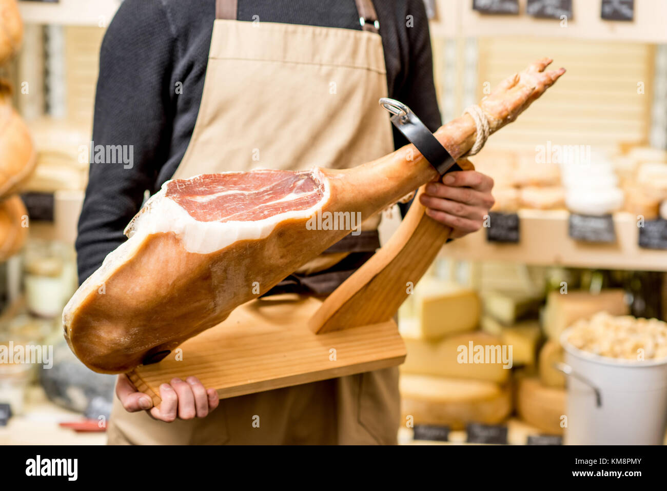 Holding incised prosciutto leg with ham holder in the shop Stock Photo