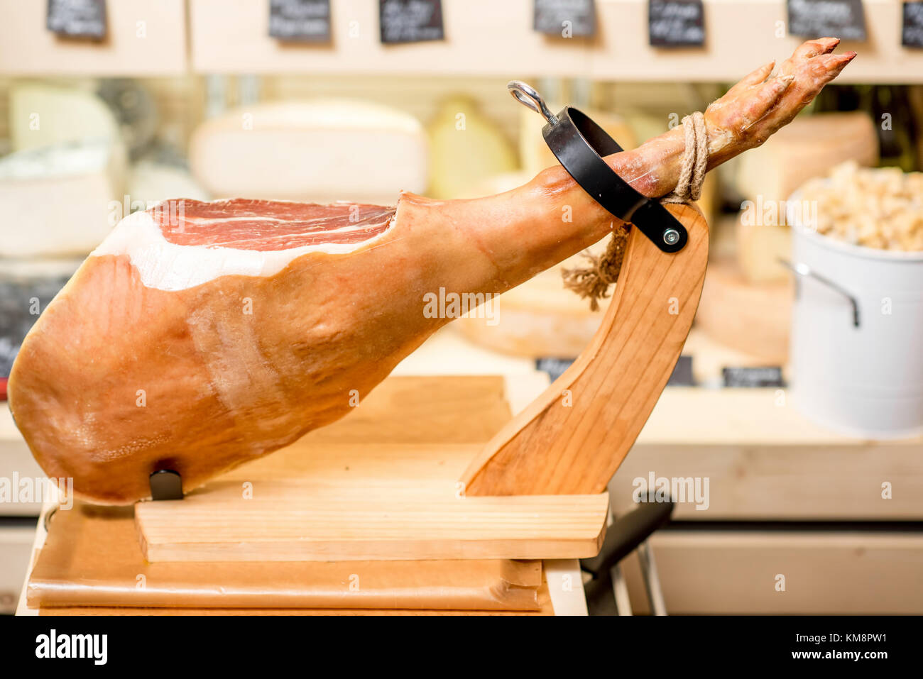 Prosciutto leg in ham holder on the table in the food store Stock Photo