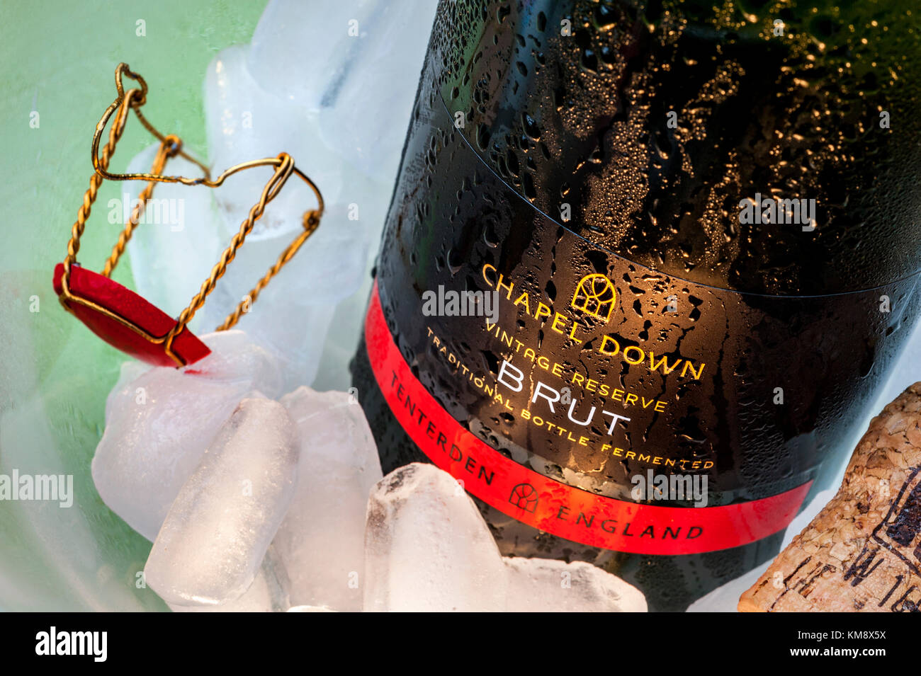 English vintage reserve sparkling wine label 'Chapel Down Brut' bottle on ice in wine cooler, with cork and retaining cap in atmospheric dining situation Stock Photo