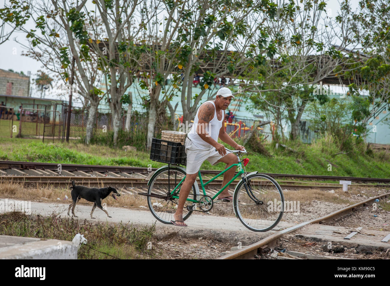 Cuban man on a bicycle crossing railway track Stock Photo