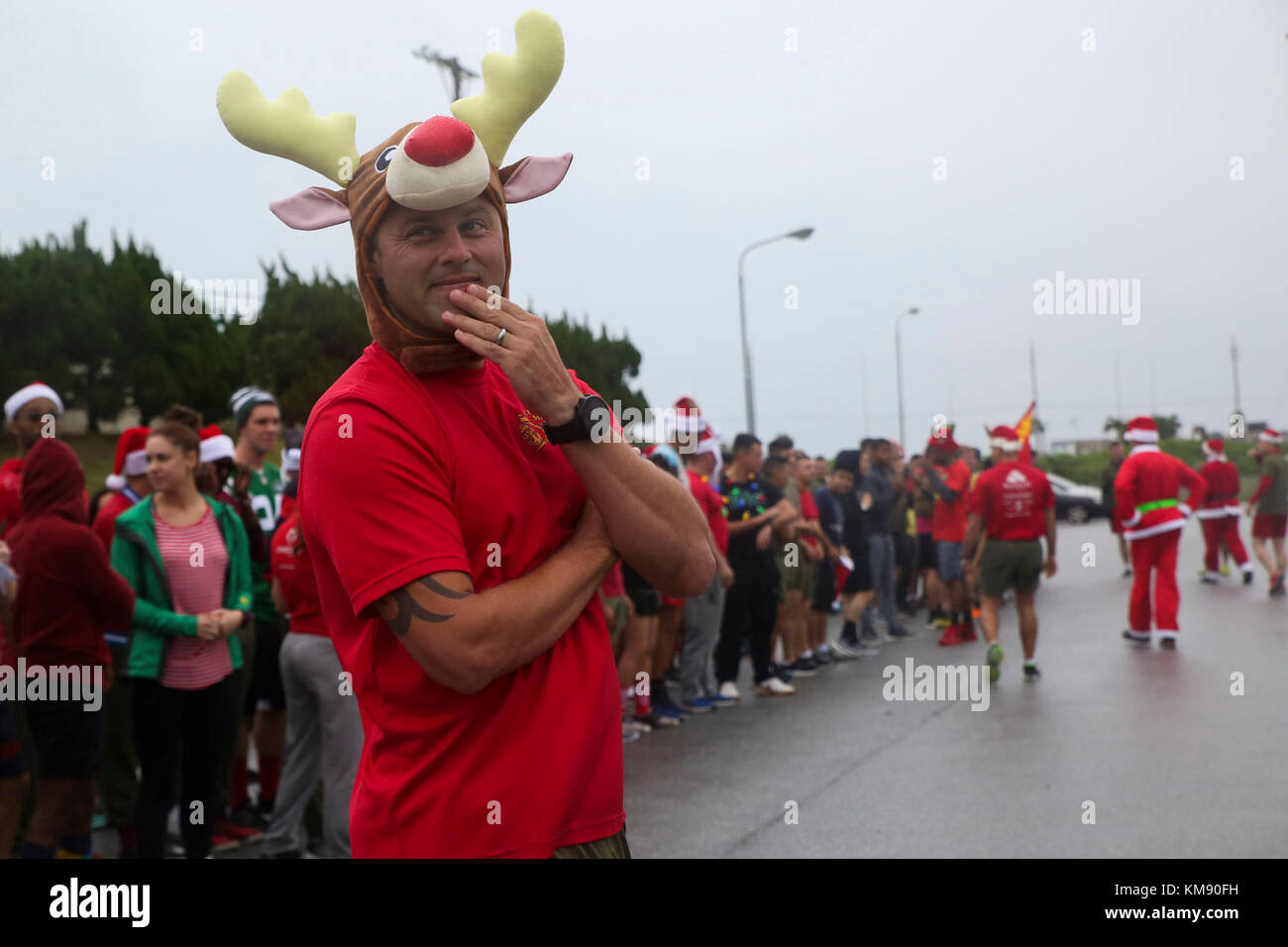 senior chief petty officer ryan auclair, senior enlisted leader with medical logistics company, 3rd supply battalion, waits for the start of the 7th annual jingle bell run hosted by marine corps community services at camp kinser, okinawa, japan dec. 1, 2017. the event featured a costumed fun run, christmas caroling, games and prizes for marines and sailors, who attended to celebrate the holiday season. Stock Photo