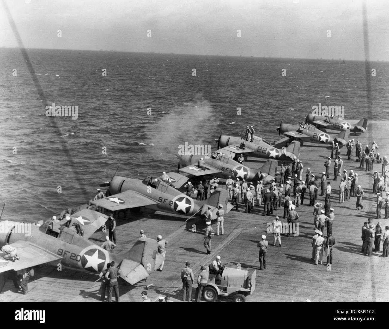 Testing machine guns of Grumman F4F-4 Wildcat fighters aboard USS Ranger (CV-4), while en route from the U.S. to North African waters, circa early November 1942. Note the special markings used during this operation, with a yellow ring painted around the national insignia on aircraft fuselages. Operation Torch Stock Photo