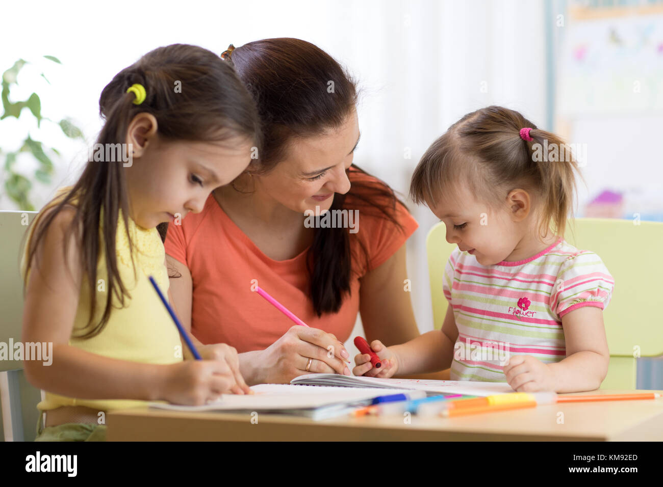 Teacher mom working with creative kids Stock Photo