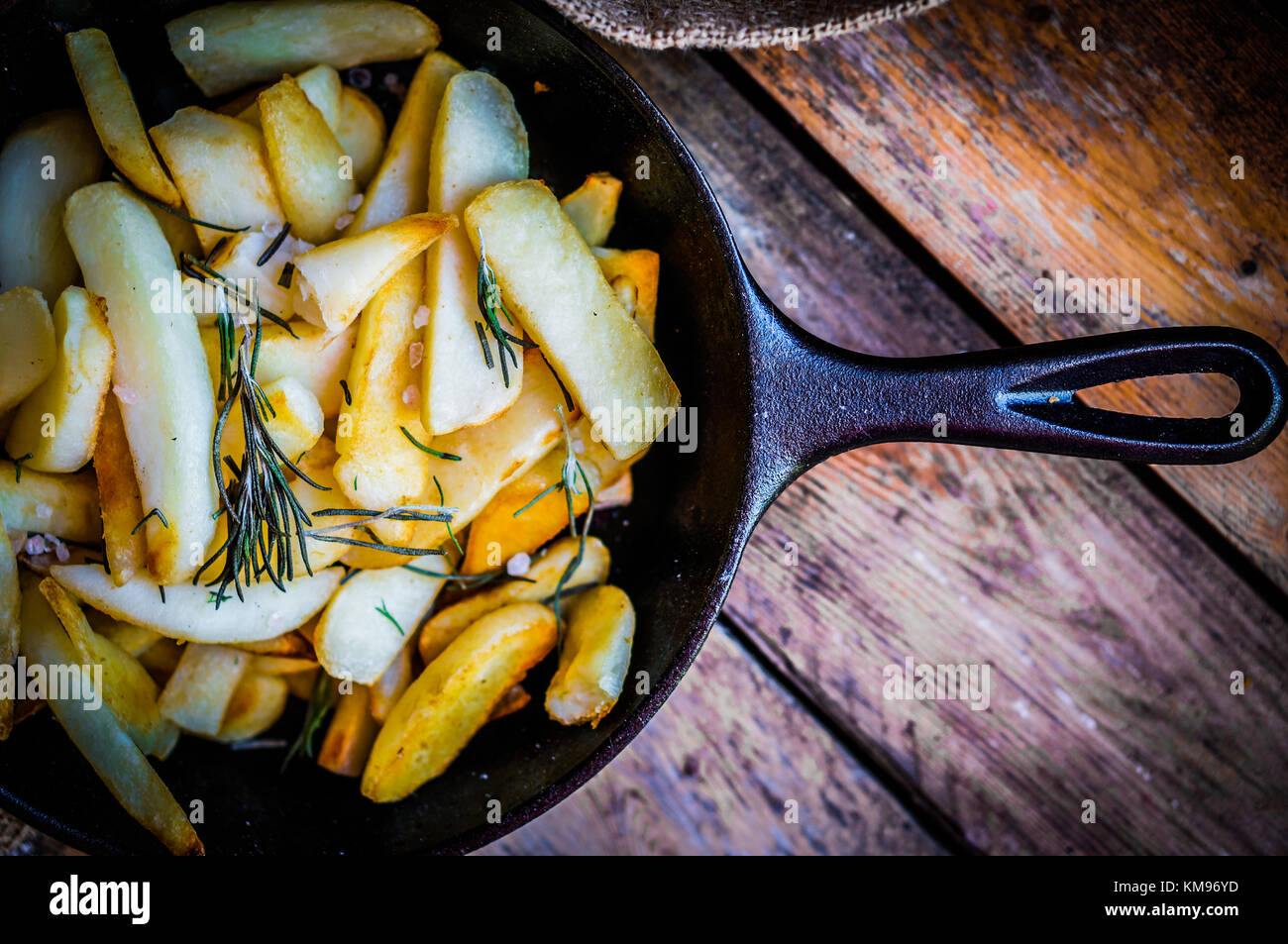 Homemade French Fries With Rosemary And Salt In Cast Iron Skillet On