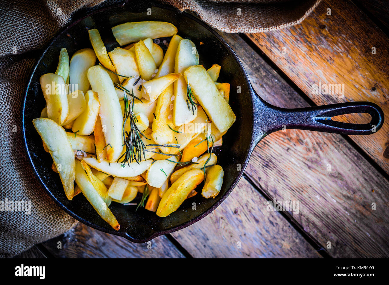 Homemade French Fries With Rosemary And Salt In Cast Iron Skillet On