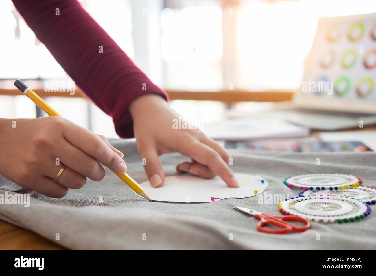 Female fashion designer working with sketches at studio and choosing ...