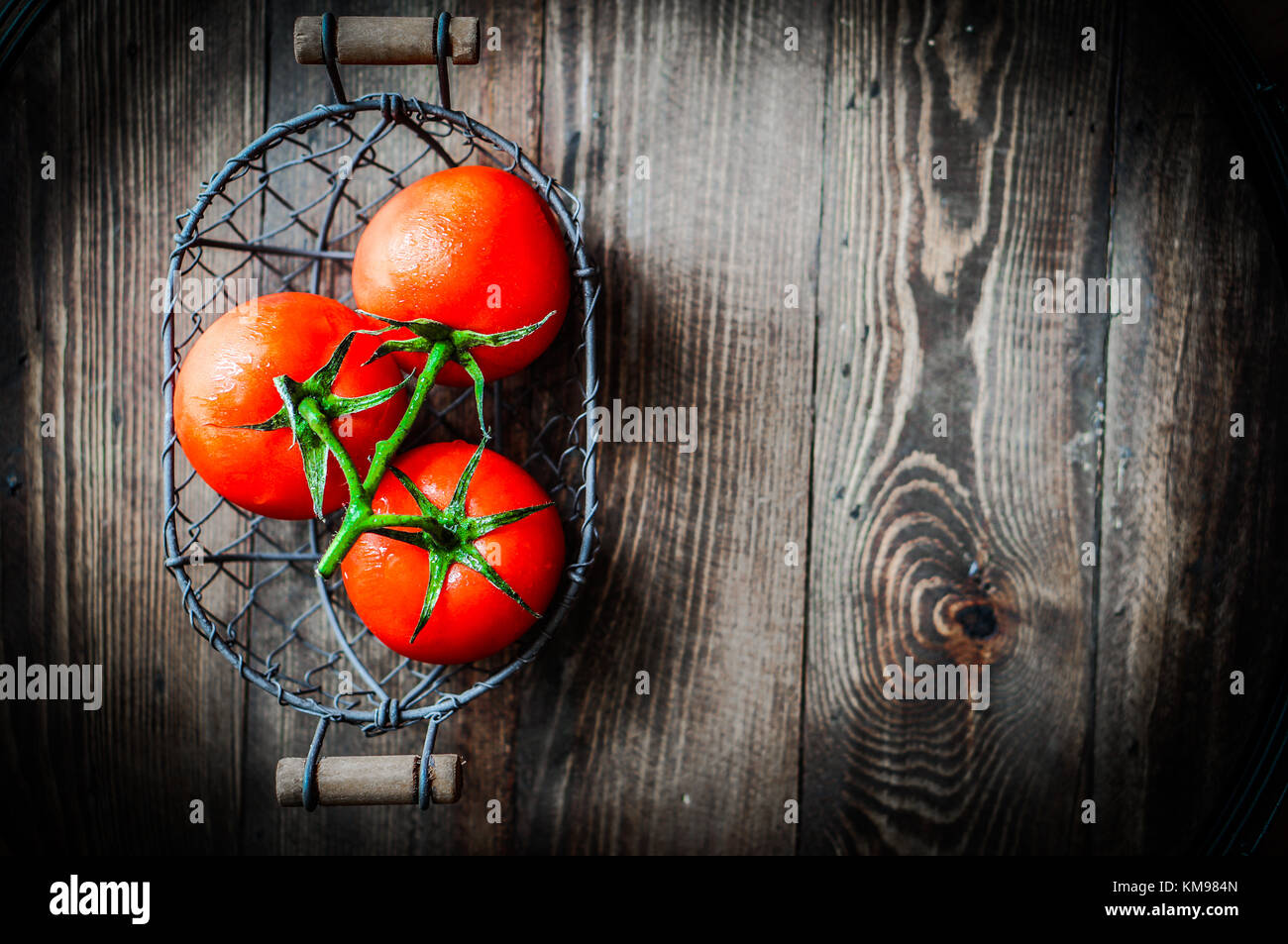 Fresh Tomatoes In Antique Basket On Wooden Background Stock Photo - Alamy