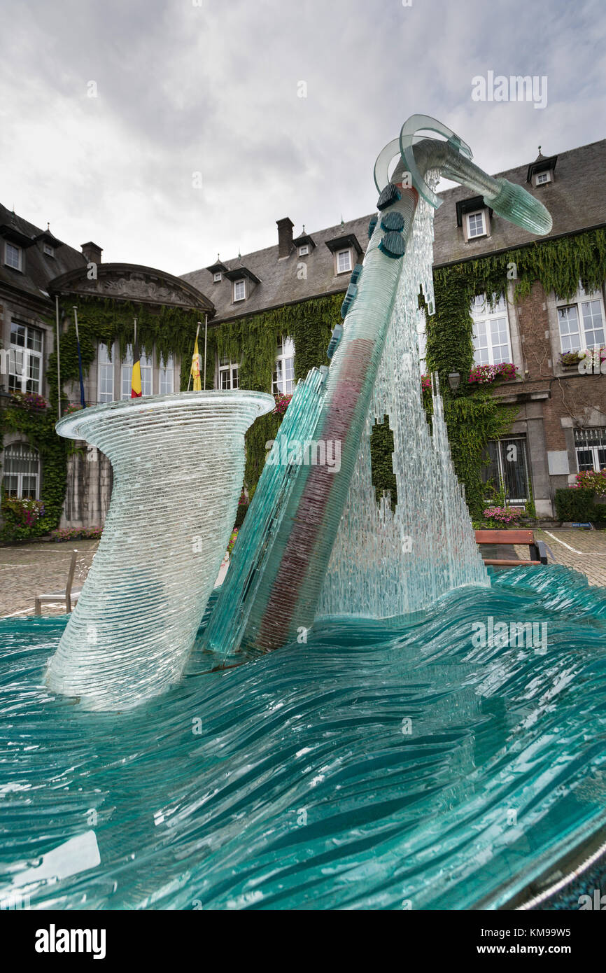 Town of Dinant, Belgium. Picturesque view of the Bernard Tirtiaux glass saxophone fountain sculpture, with Dinant Town Hall in the background. Stock Photo